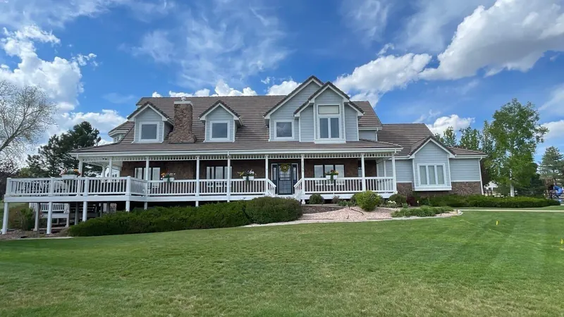 Repainted tan farmhouse-style home with wraparound porch in Centennial