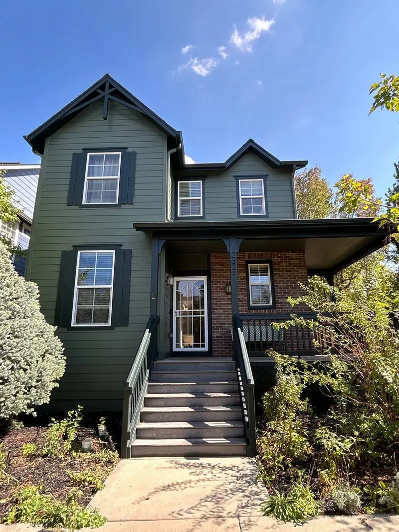 Repainted green craftsman home with brick porch in Denver's Central Park neighborhood