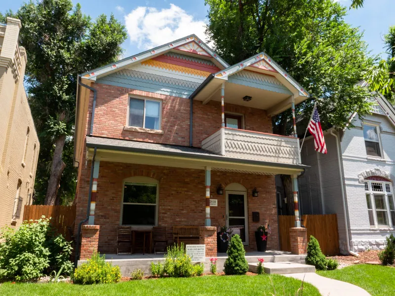Freshly repainted two-story brick home with colorful gable trim in Denver's City Park neighborhood